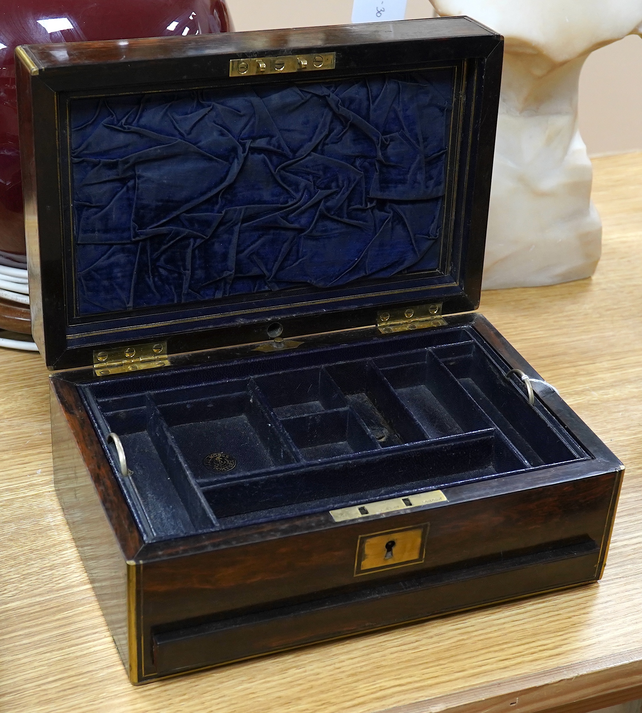 A Victorian brass bound coromandel wood jewellery casket, with velvet lined lid, a fitted leather and velvet top compartment shelf and base lower drawer. 13cm high x 28cm wide. Condition - some splits to the veneer on th